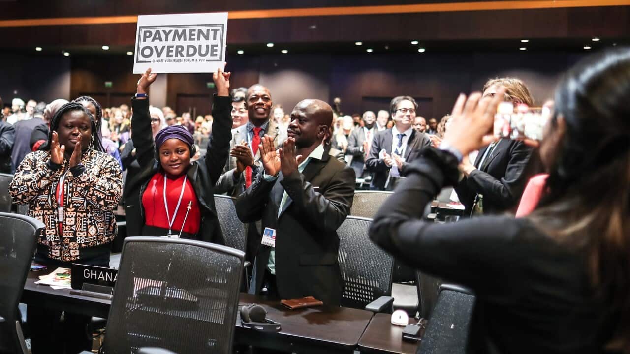 Nakeeyat Sam Dramani, a young poet from Ghana, holds a placard with the words 'payment overdue' after giving a speech about global warming during the COP27 summit.