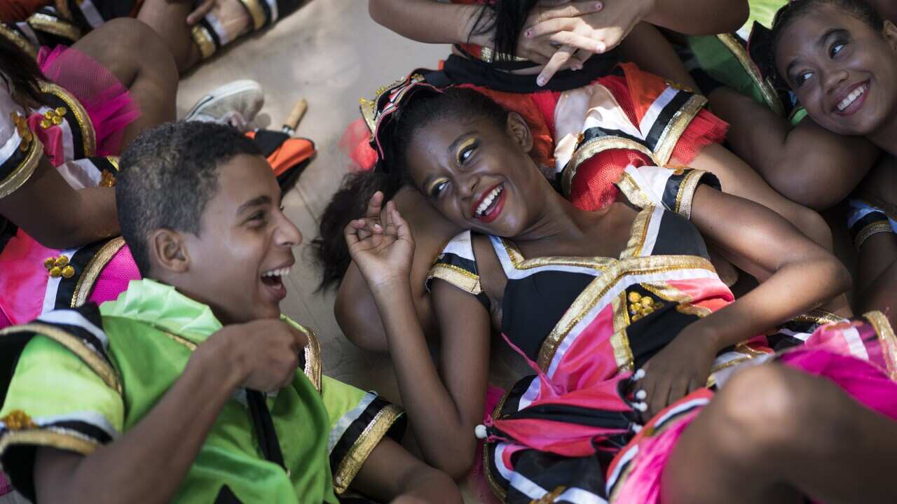 Brazilians joke with each other as they lay on the shade during the "Burial of the Mosquito" carnival block to raise awareness about the dangers of the Aedes aegypti 