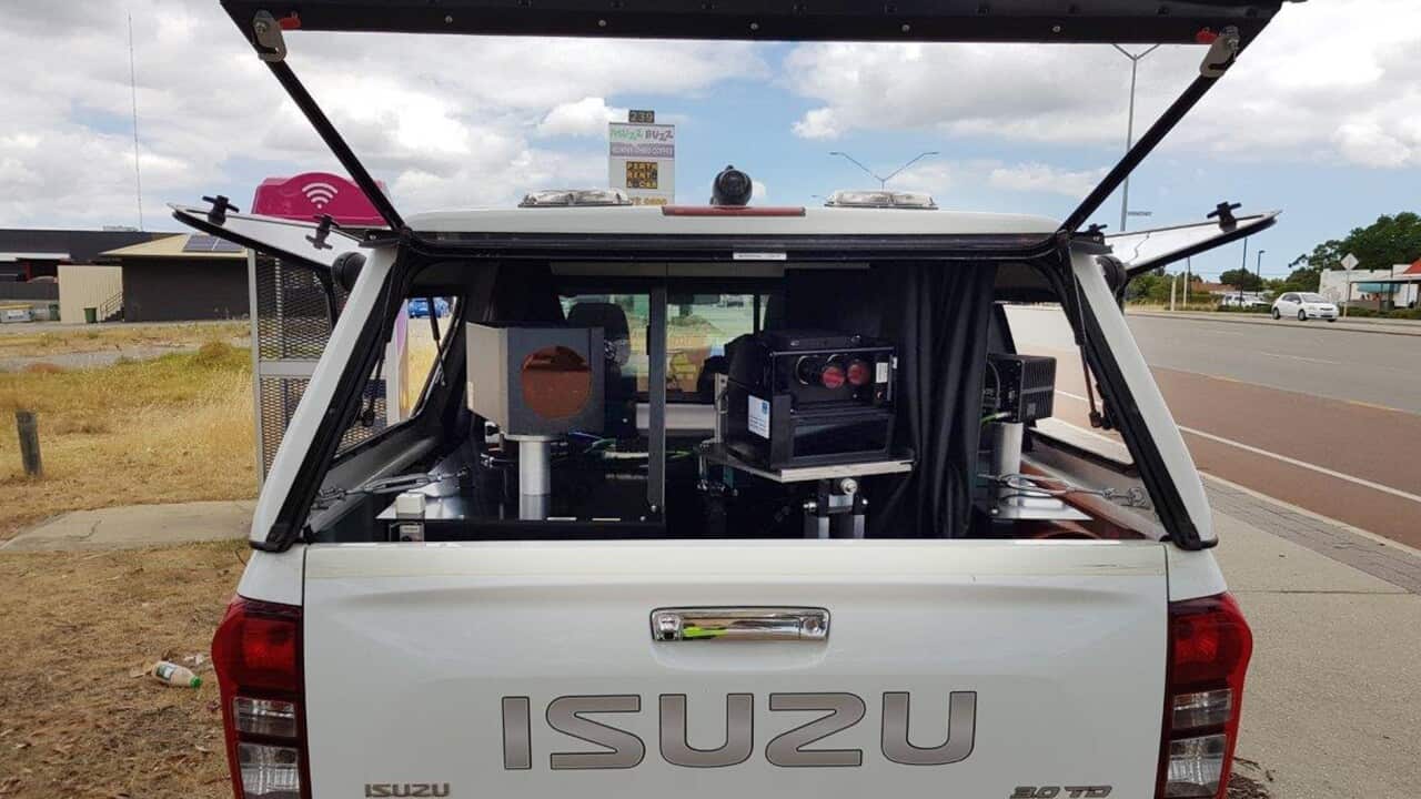 A mobile speed camera in the back of a white Isuzu ute.