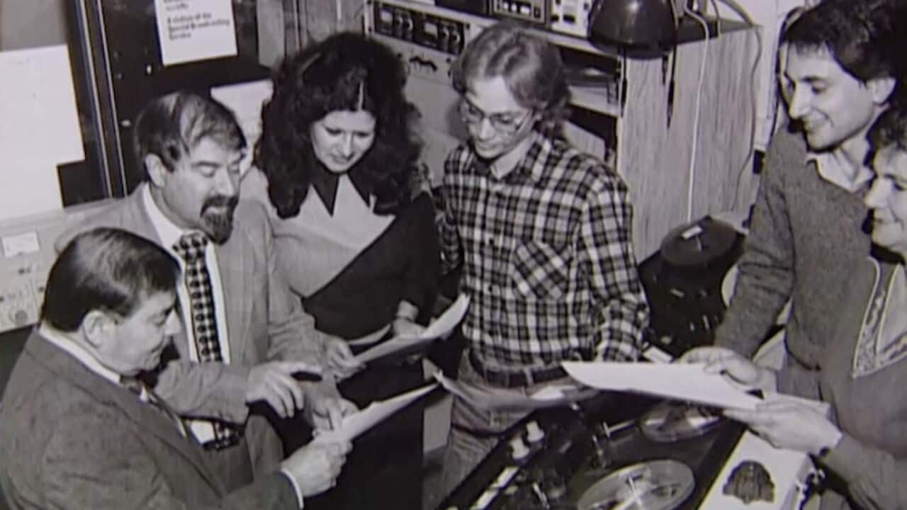 A group of six broadcasters inside the broadcast studio.