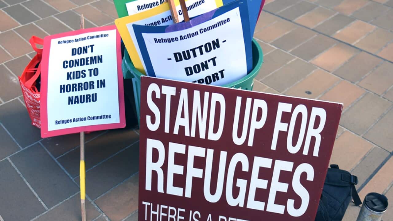 Asylum seeker advocate signs outside the High Court of Australia