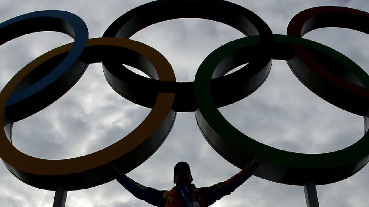 A volunteer poses with the Olympic Rings in Sochi