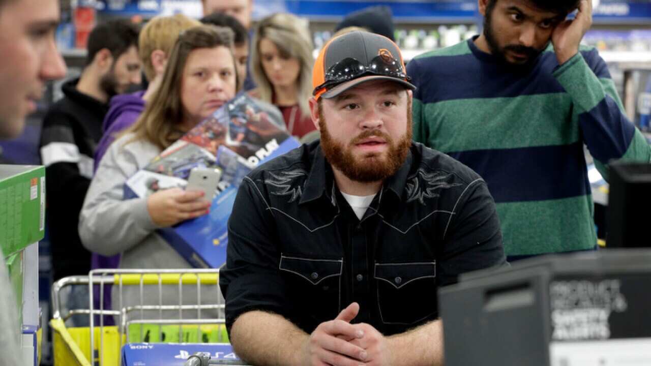 people line up to check out as they shop a Black Friday