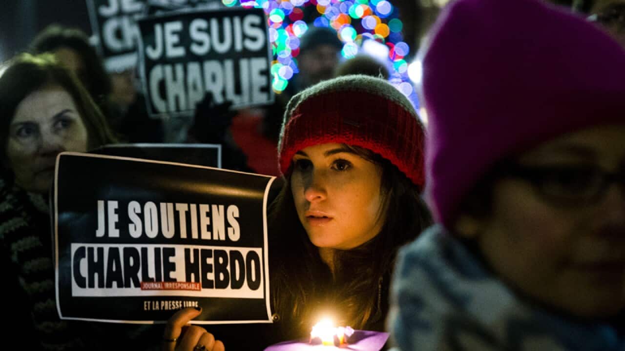 People gather to pay tribute to victims of the Charlie Hebdo