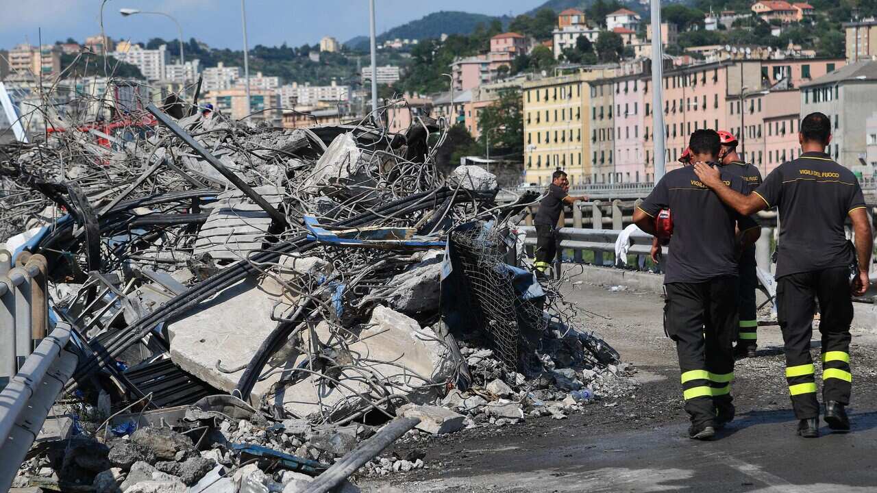 Firemen work at the site of the partially collapsed Morandi bridge in Genoa.
