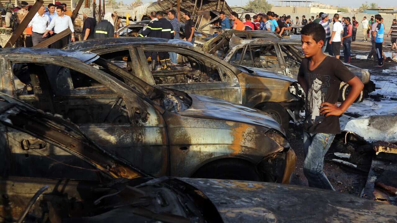 Civilians gather at the scene of a deadly car bomb in the Habibiya neighborhood of Sadr City, Baghdad, Iraq, Saturday, Aug. 15, 2015. (AP Photo/Karim Kadim)