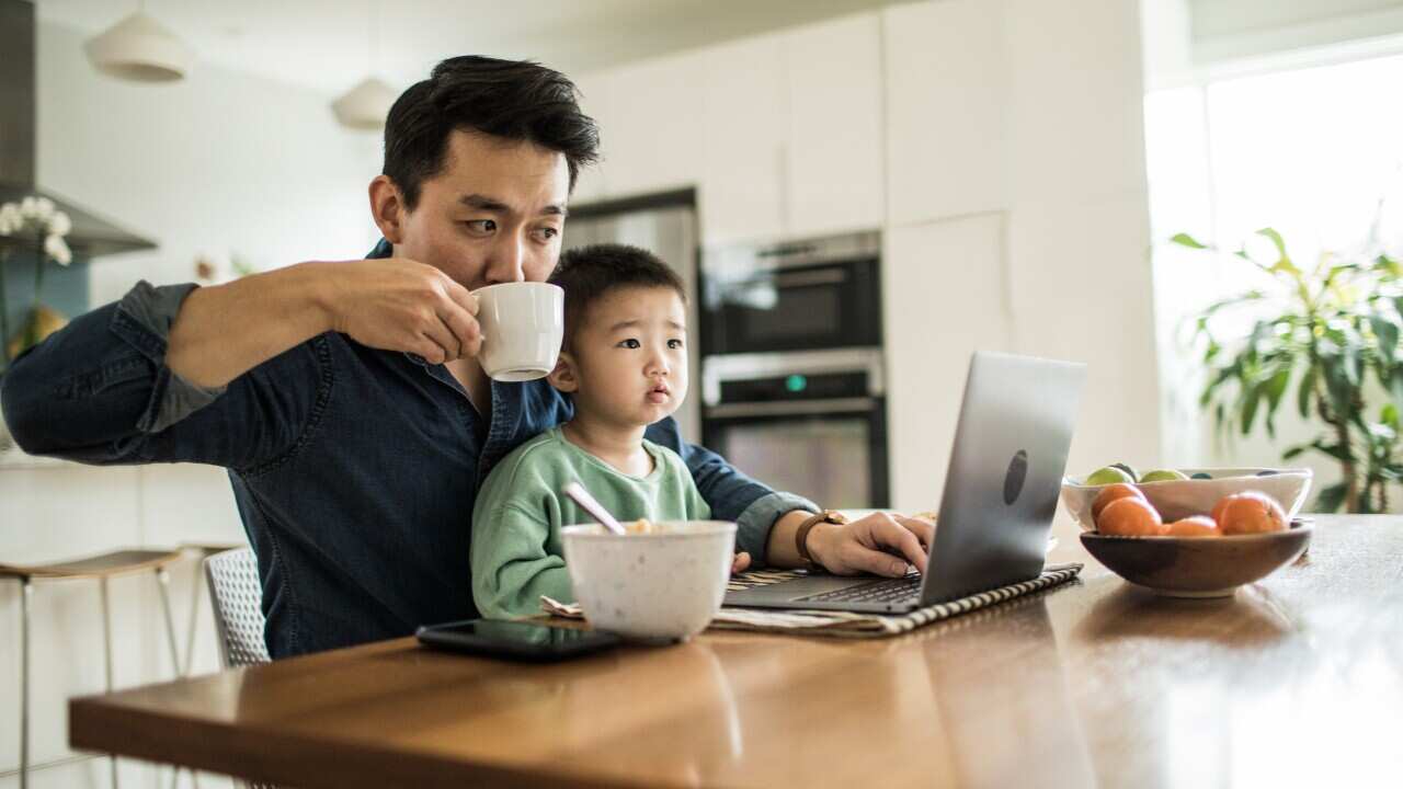 Father and son having breakfast while workin