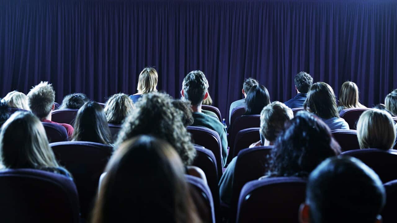 Crowd of people in movie theater, rear view