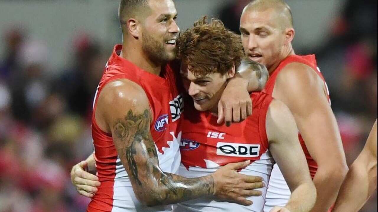 Gary Rohan (centre) of the Swans celebrates with Lance Franklin.