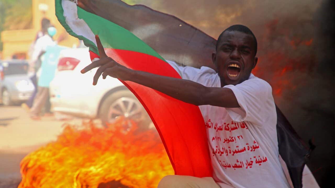 Mwandamanaji ashika bendera ya Sudan katika maandamano yanayo unga serikali yakiraia mjini Khartoum, Sudan.