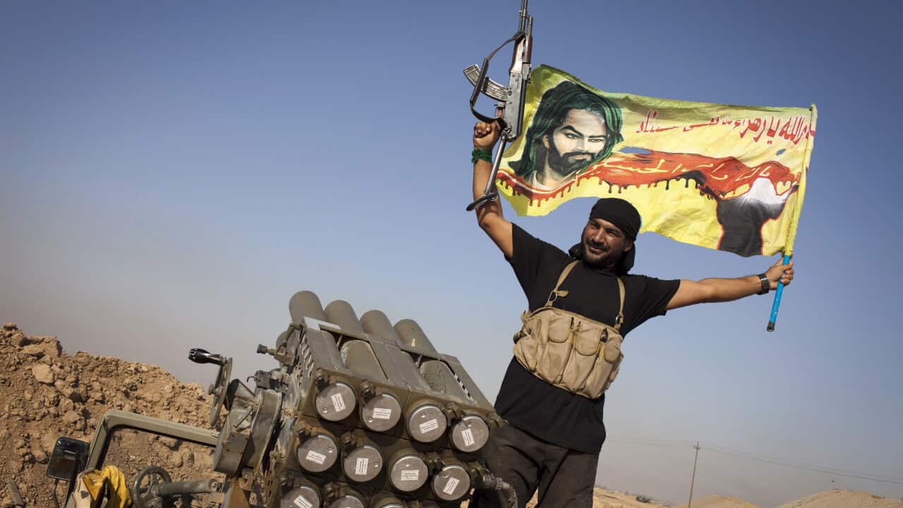 An Iraqi militia fighter from Shiite cleric Moqtada al-Sadr's Saraya al-Salam (Peace Brigade), waves a flag next to a rocket launcher during heavy clashes with Islamic State (IS) fighters in Tuz Khurmatu in Salaheddin province south of Kirkuk. (JM LOPEZ/G