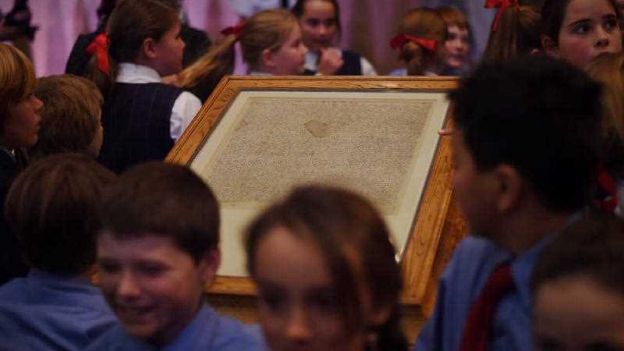 School kids around "Magna Carta" at Parliament House in Canberra, Monday, June 15, 2015. (AAP Image/Lukas Coch) 