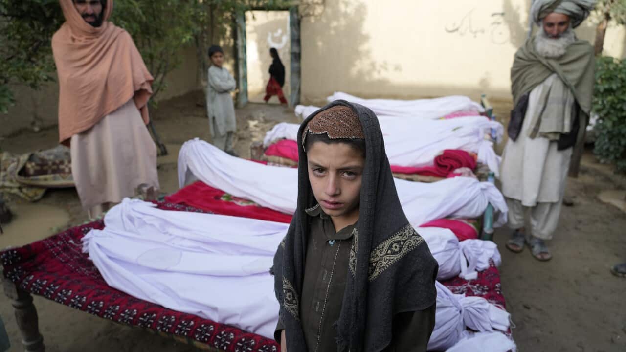 Men stand around the bodies of people killed in an earthquake in Gayan village, in Paktika province, Afghanistan.