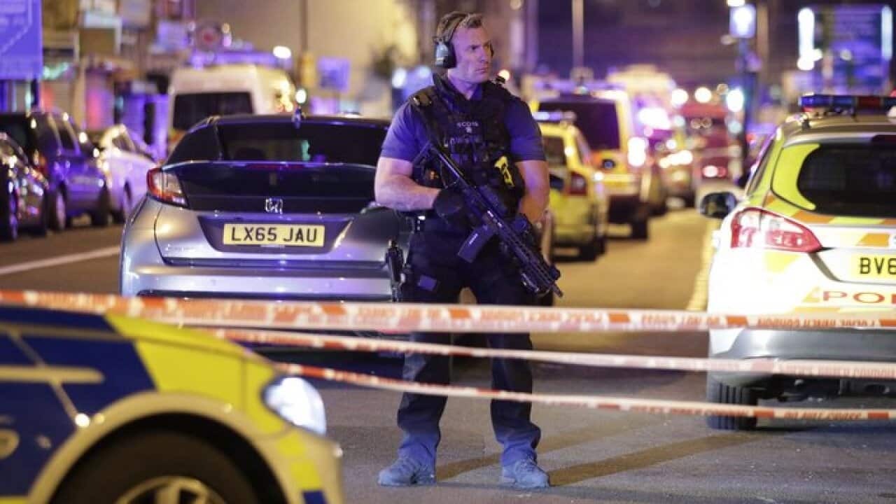 An armed police officer mans a cordon on the Seven Sisters Road at Finsbury Park in north London,