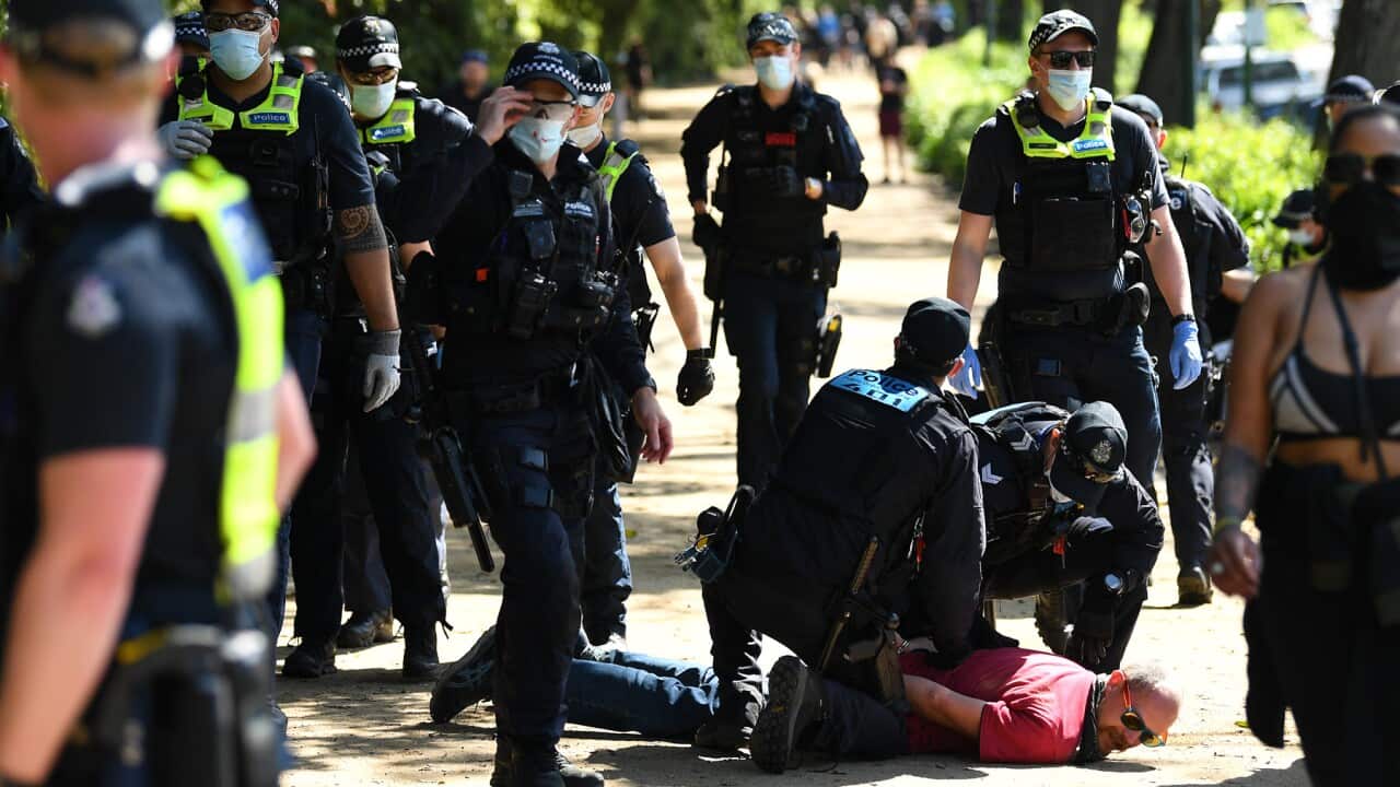 Victoria Police detain a protester near the Royal Botanic Gardens during an anti-mandatory vaccination protest in Melbourne, Saturday, October 2, 2021