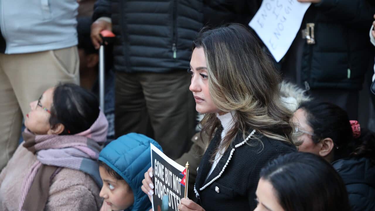 Nepal Vigil Melbourne: A woman is seen holding a placard at a vigil in Melbourne's Federation Square. 