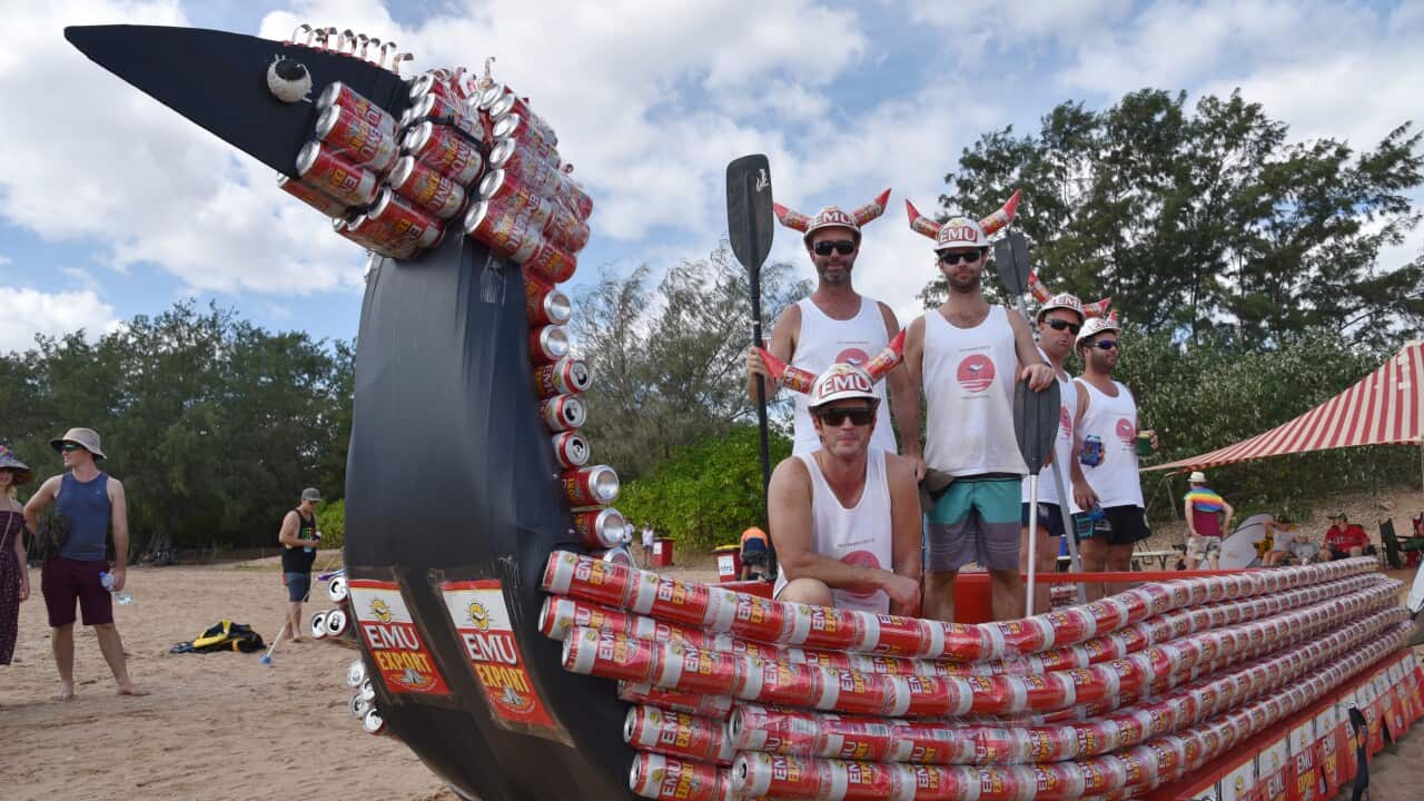 Grupo de competidores com um barco em formato de emu feito com latas de cerveja
