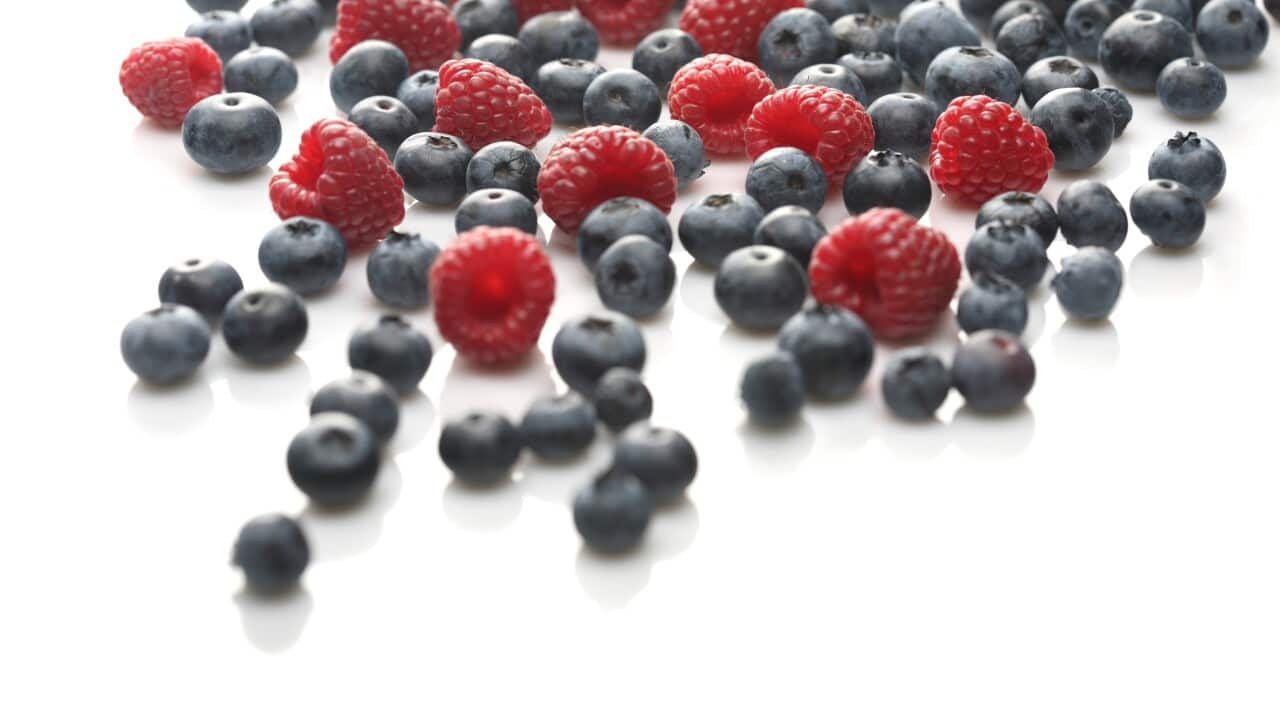 Raspberries and blueberries on white background