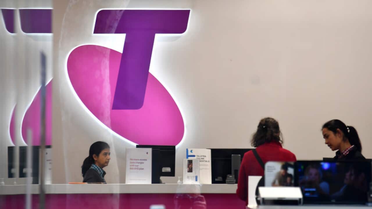 Customers and assistants at a Telstra store