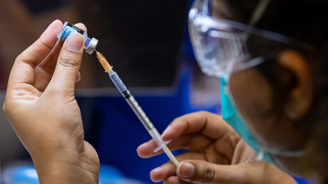 A health care worker prepares a Pfizer vaccine in the pharmacy of the Heidelberg Repatriation Hospital vaccination hub in Melbourne