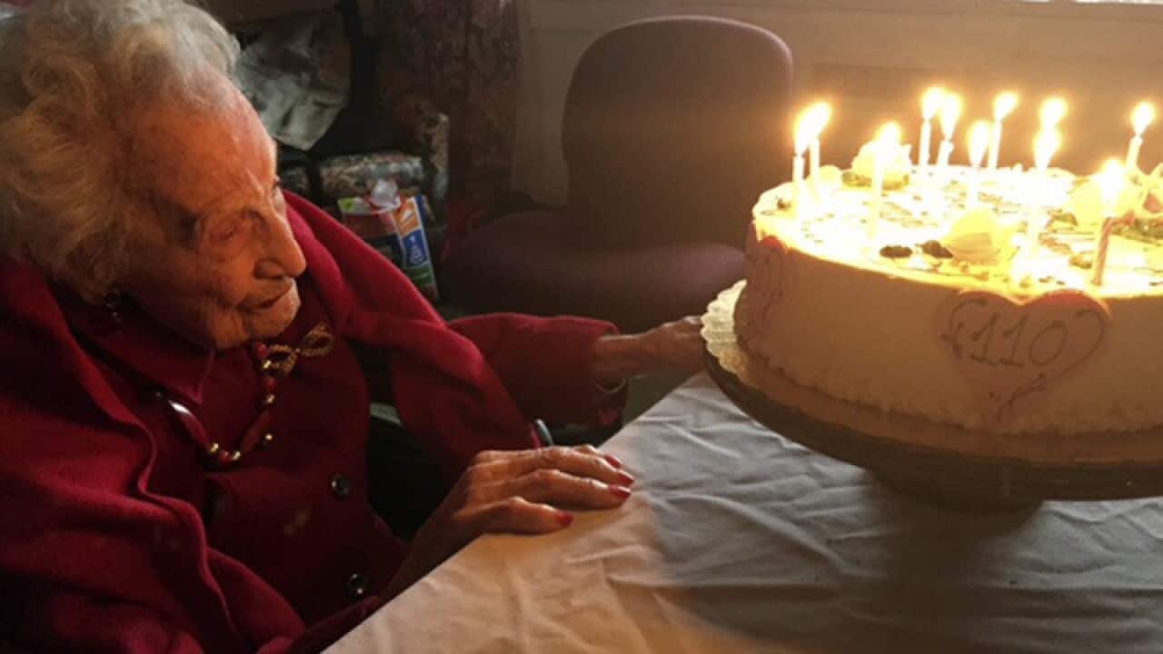 Emily Tremonti sits in front of her cake