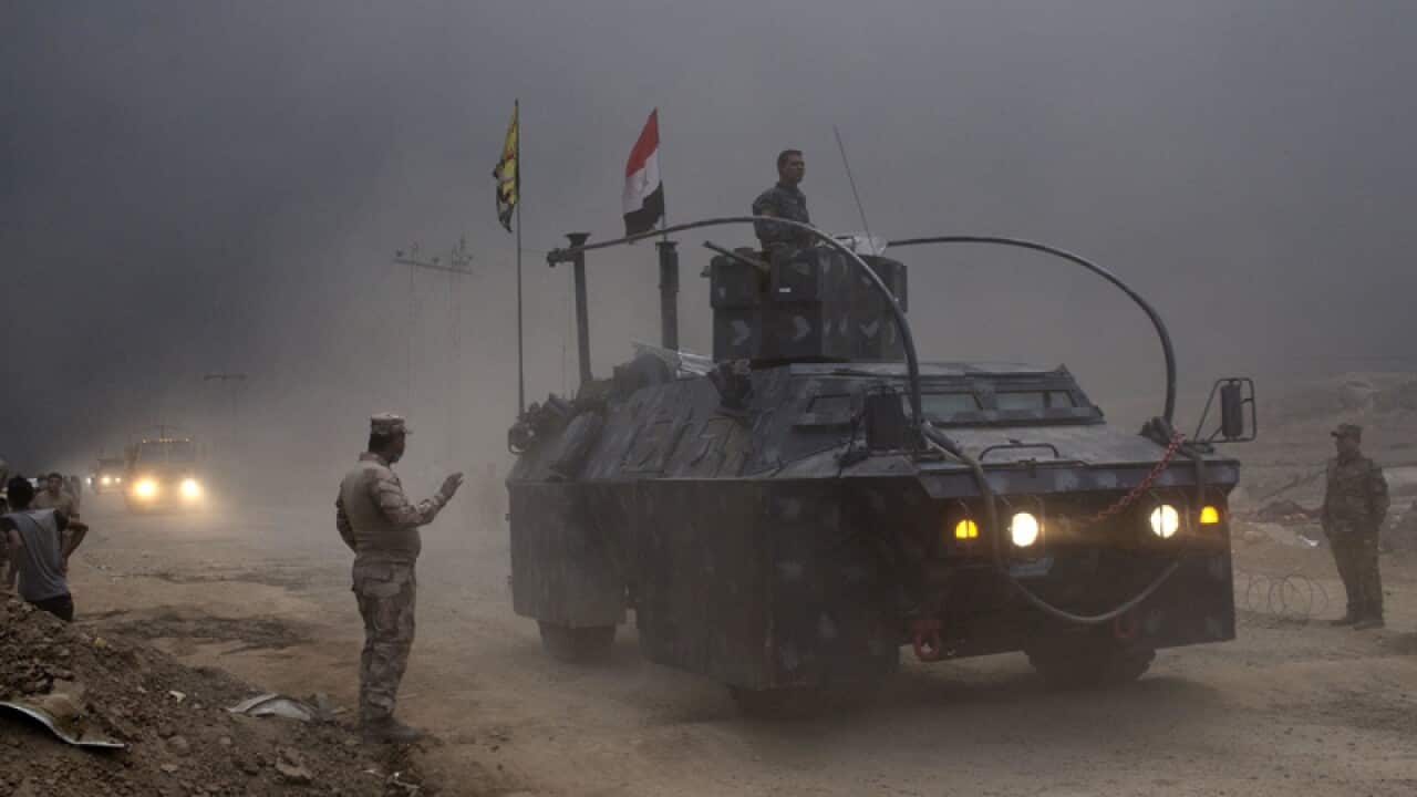 An Iraqi federal police vehicle passes through a checkpoint
