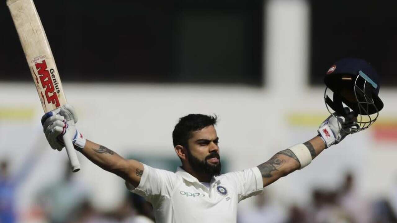 India's captain Virat Kohli raises his bat and helmet