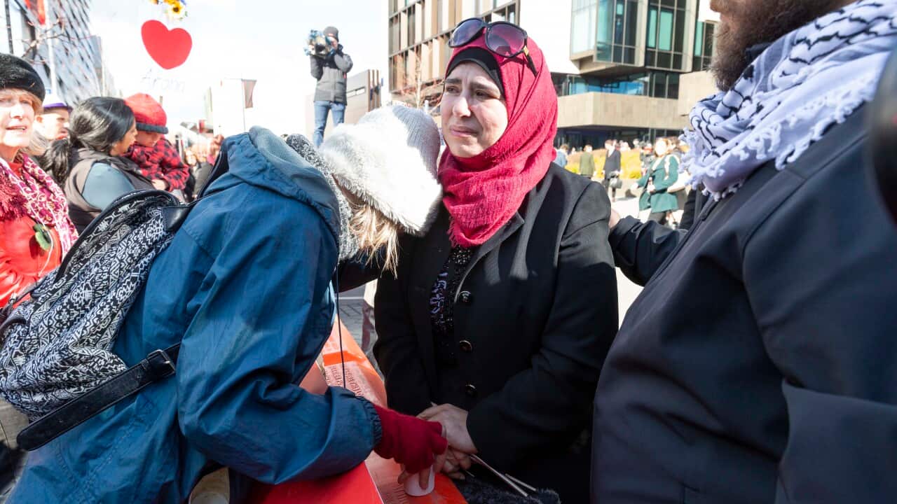 Emotional people embrace on the street.