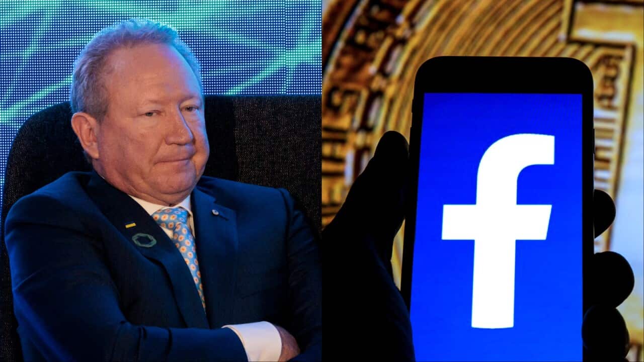 A phone with the Facebook logo being held in front of a Bitcoin symbol.
