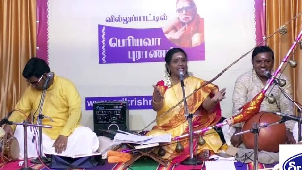 Bharathi Thirumagan on stage with her son to her right and her husband to the left