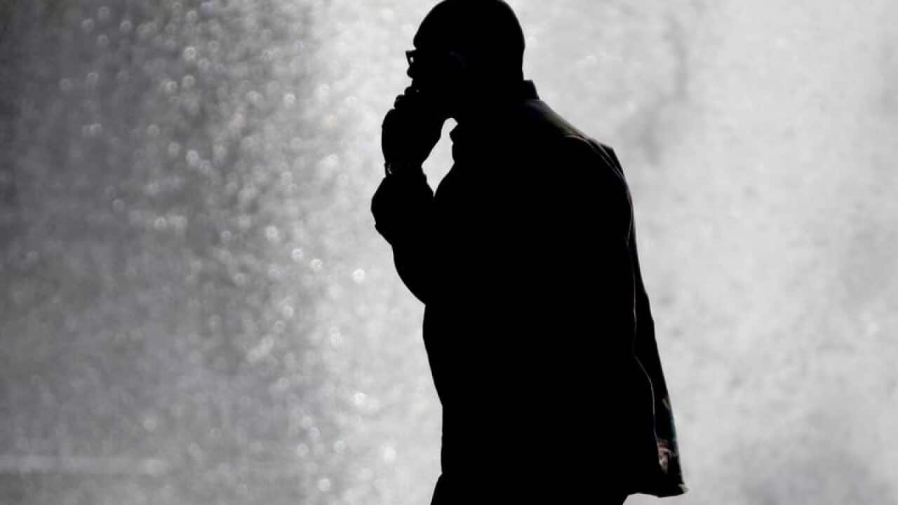 A pedestrian talking on a mobile phone.