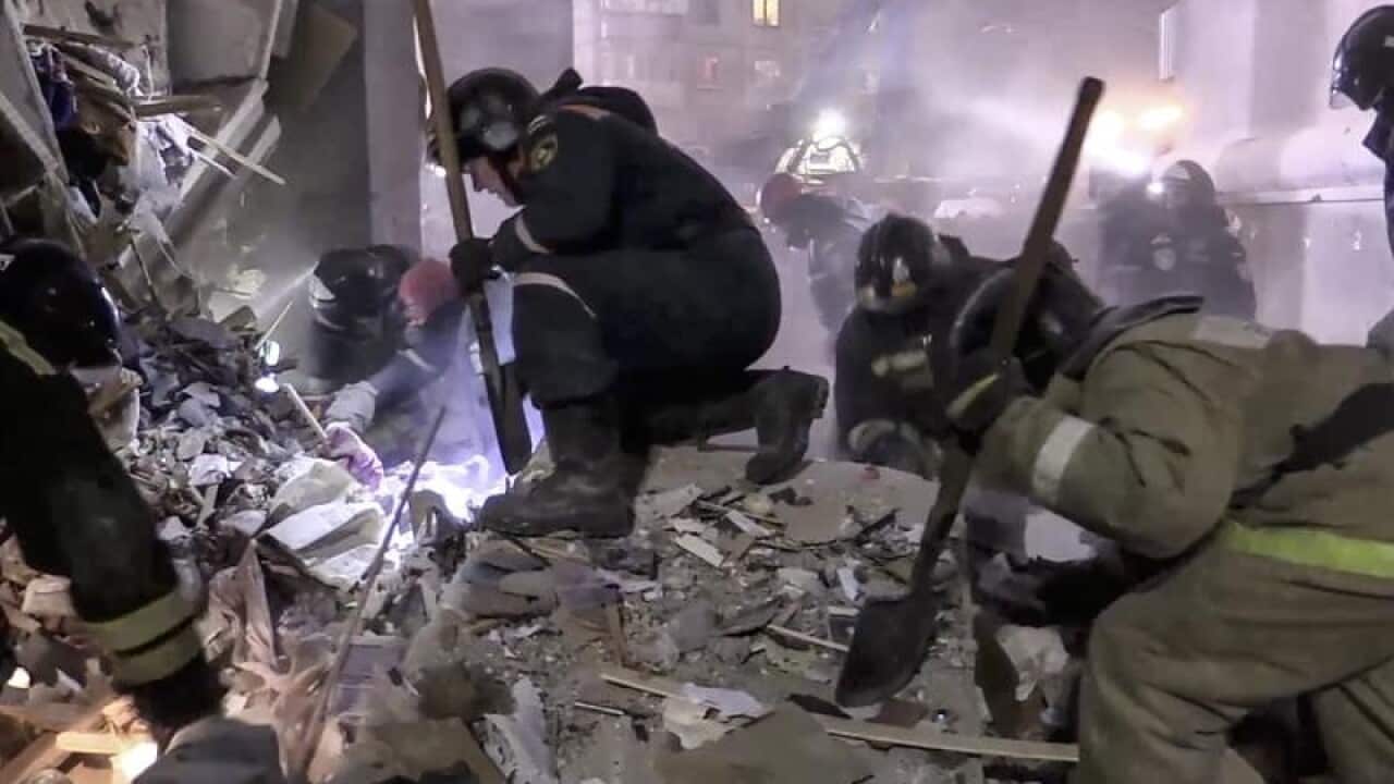 Emergency workers at the scene of a collapsed section of an apartment building in Russia.