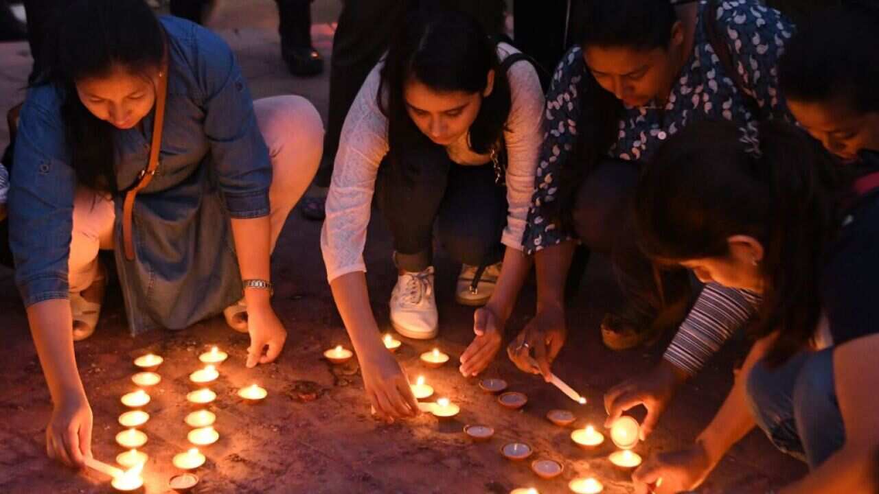 Nepali youth activists light candles during a vigil in memory of the victims of acid attacks in Kathmandu on September 27, 2018.