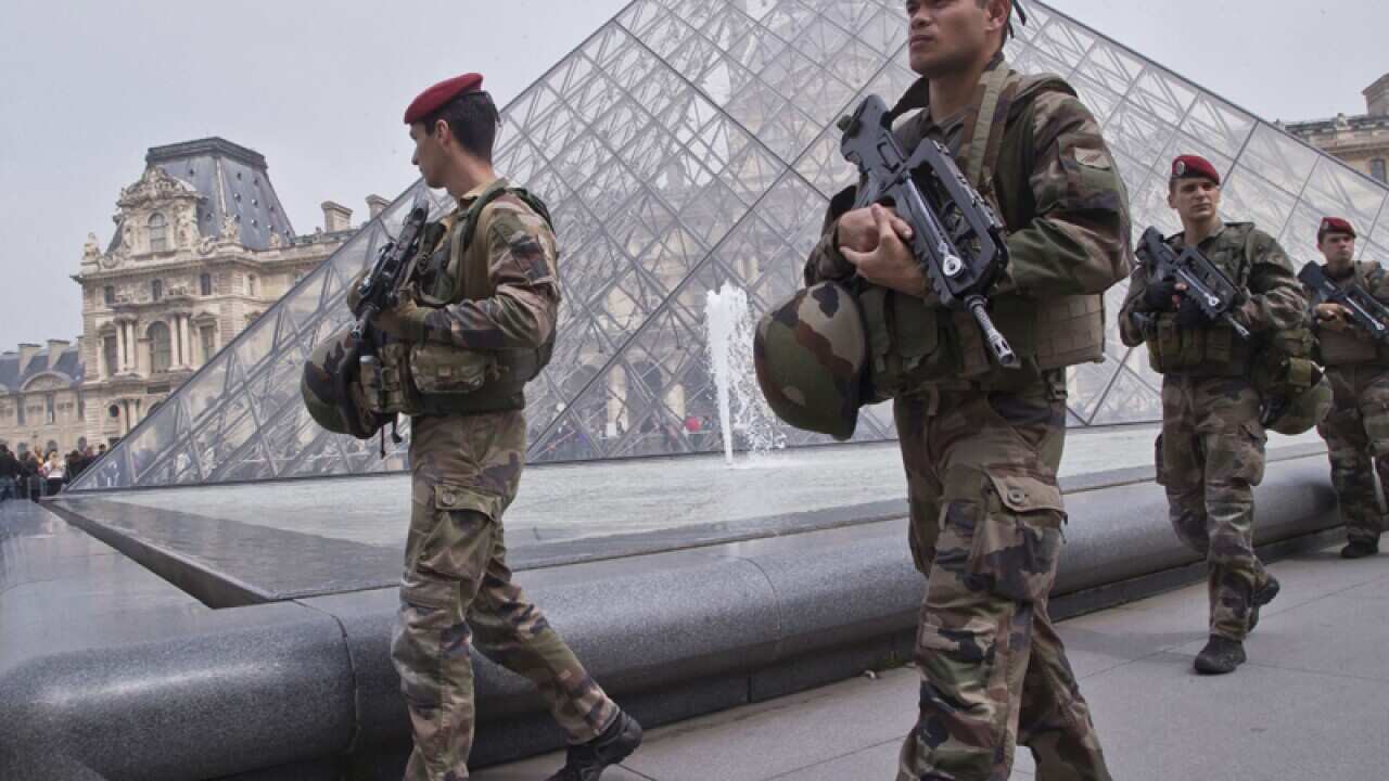 French soldiers patrol by the glass pyramid at the Louvre