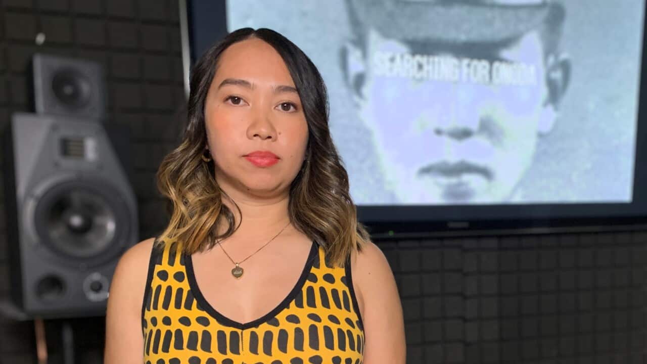 Film maker Mia Stewart standing in front of a photo of Hiroo Onoda 