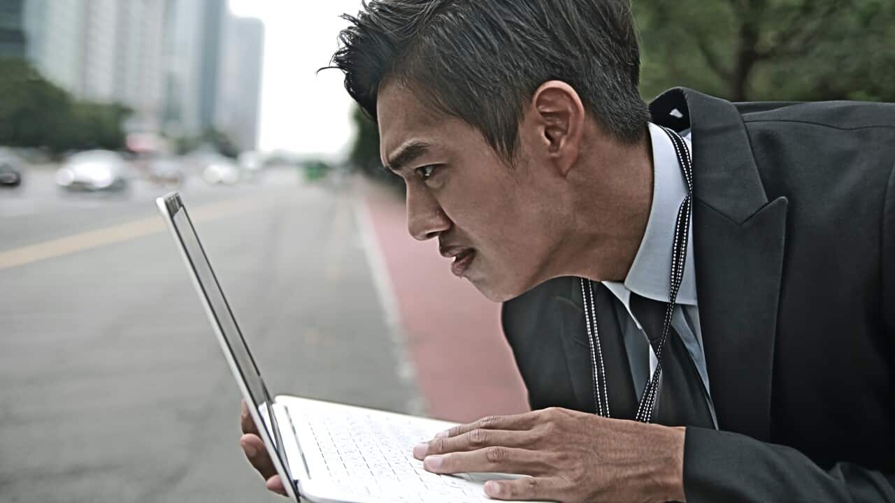 Businessman using laptop in city