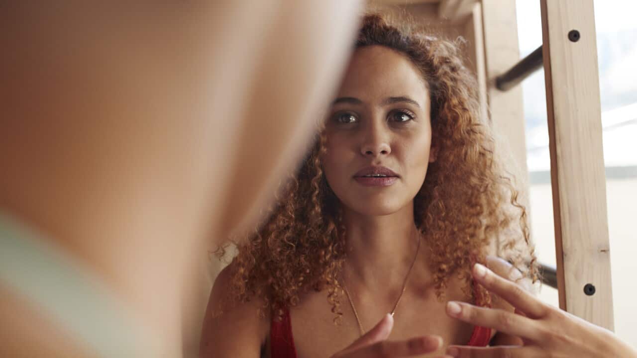 Close-up young women talking, while sitting in bunk bed