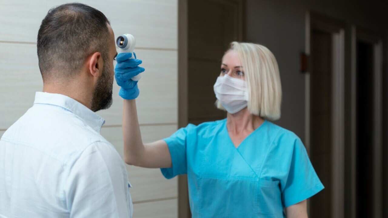 Female doctor checking temperature (Ozgurdonmaz - Getty
