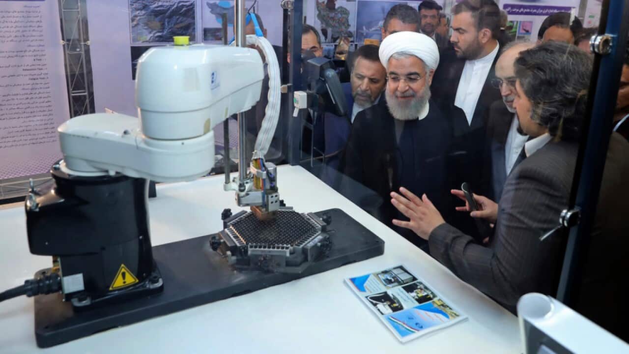 President Hassan Rouhani listens to explanations on new nuclear achievements at a ceremony to mark National Nuclear Day, in Tehran