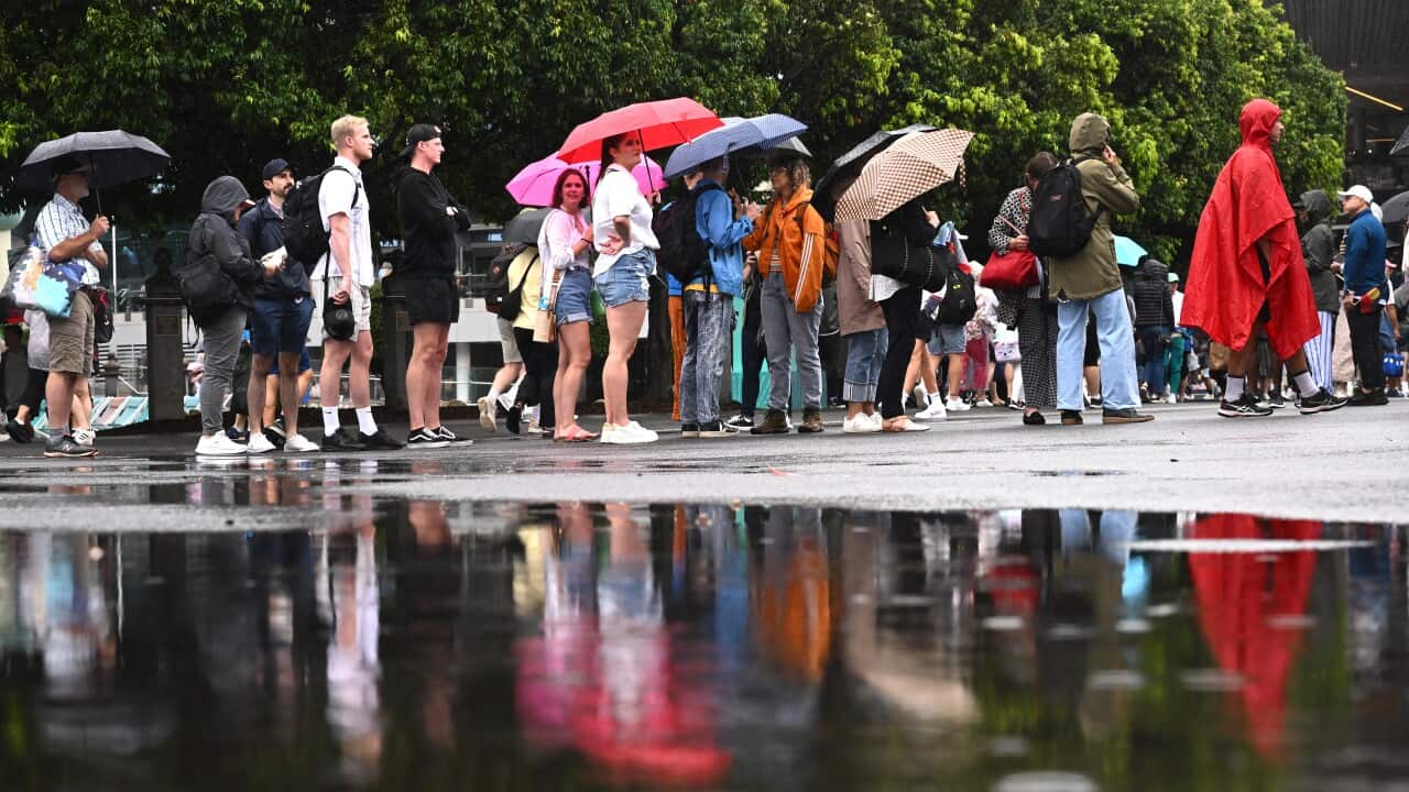 People are seen during wet weather at Melbourne Park in Melbourne.