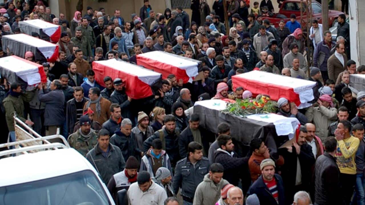 Syrian citizens carrying coffins of the victims of a car bomb