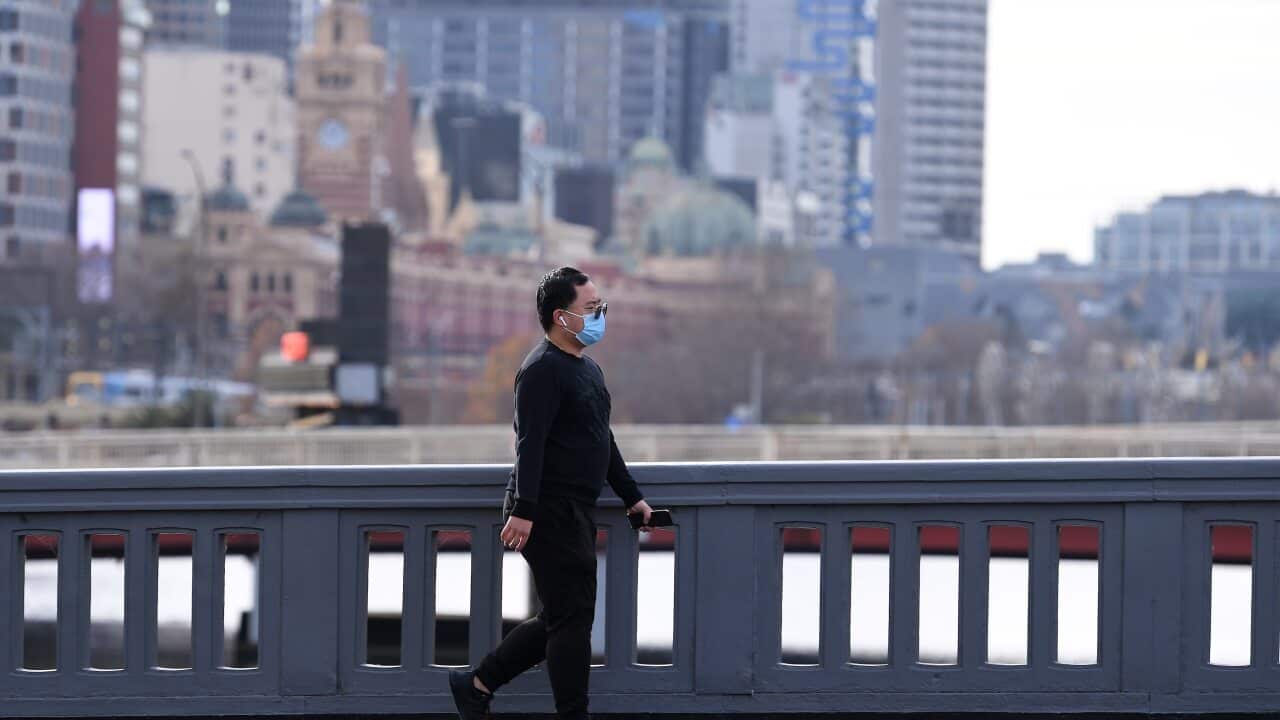 A person wearing a face mask is seen walking across a bridge in Southbank, Melbourne, Saturday, June 5, 2021. Victoria has recorded five new cases of locally acquired coronavirus in the past 24 hours. (AAP Image/James Ross) NO ARCHIVING