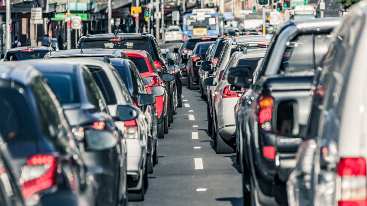 A group of cars stuck in traffic on a busy road.