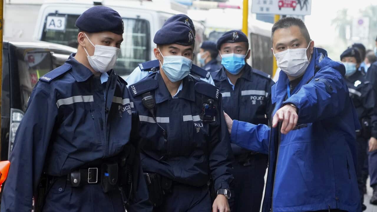 Police officers guard outside the building of the Stand News office in Hong Kong.