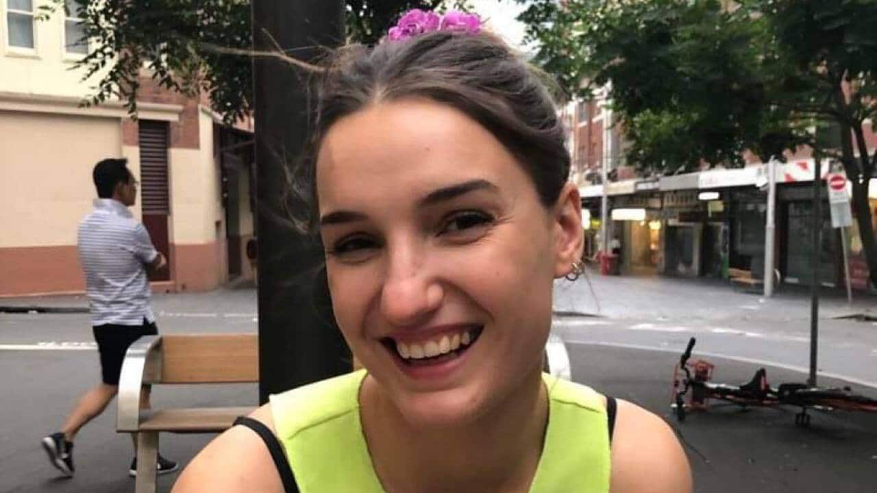 A woman sitting down and smiling outside