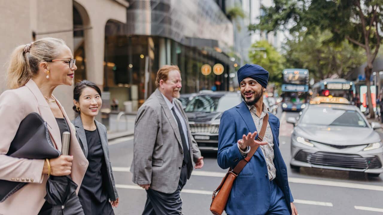 Confident business group casually converses on street