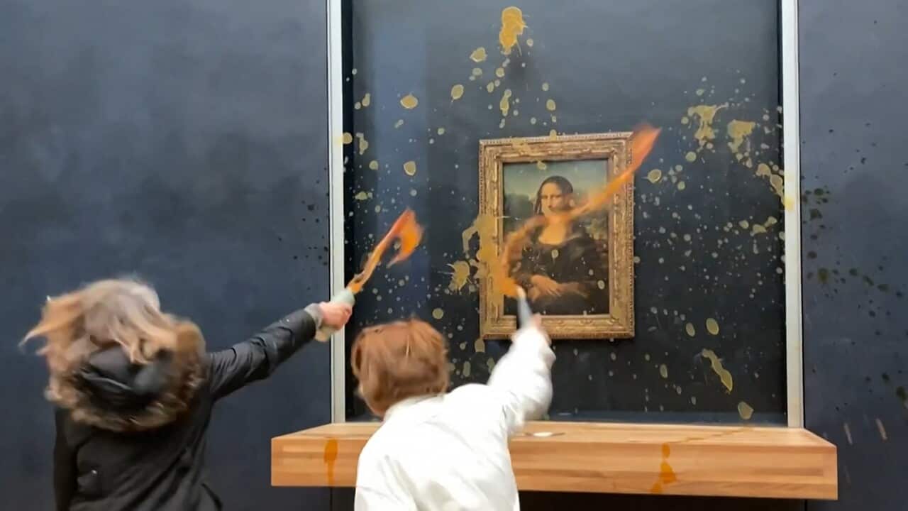 Two environmental activists from the collective dubbed Riposte Alimentaire (Food Retaliation) hurling soup at Leonardo Da Vinci's Mona Lisa.