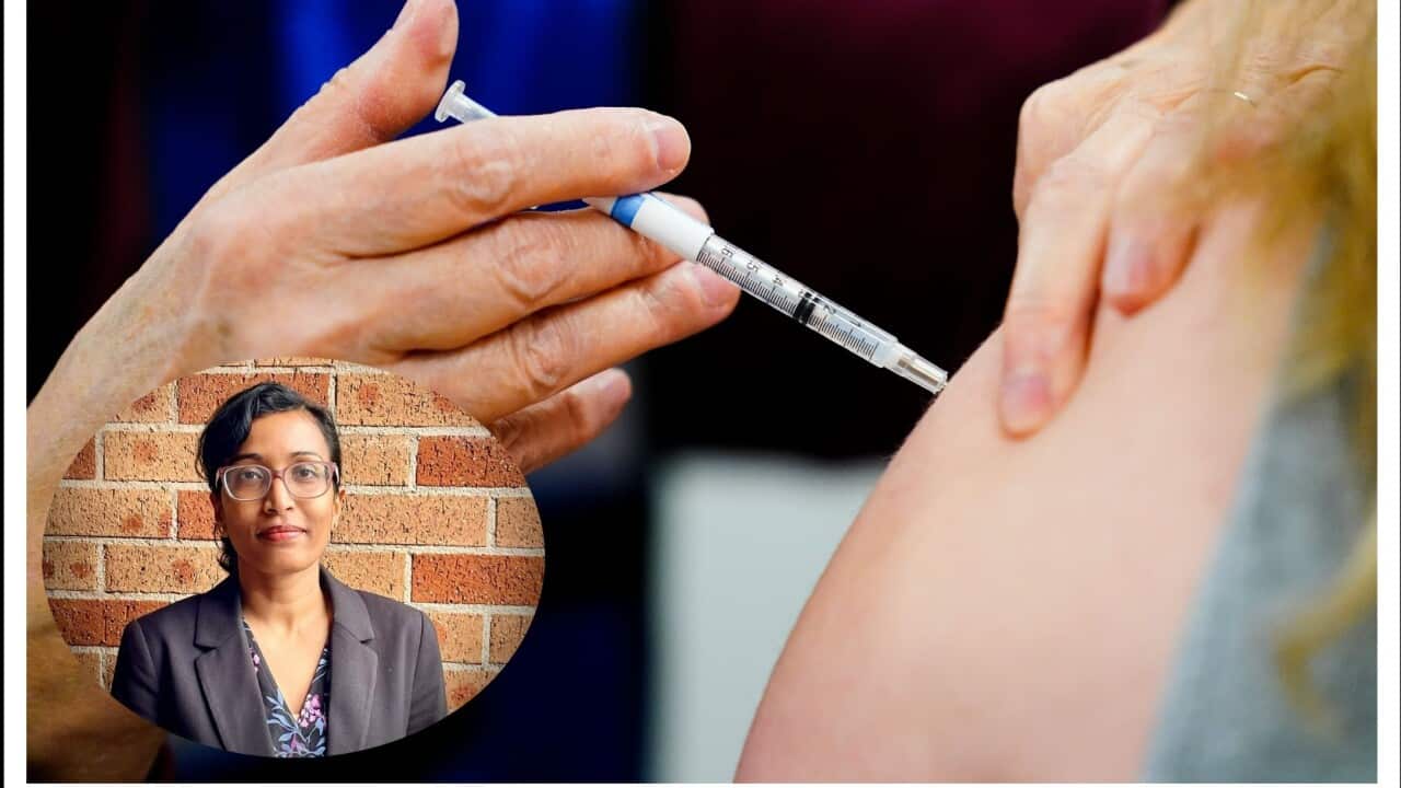 A health worker administers a dose of a COVID-19 vaccine