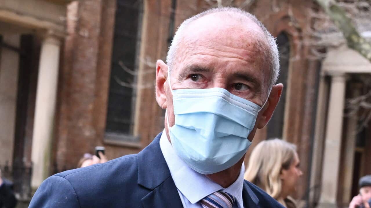 Chris Dawson, wearing a suit and a face mask, arrives at the Supreme Court of NSW.