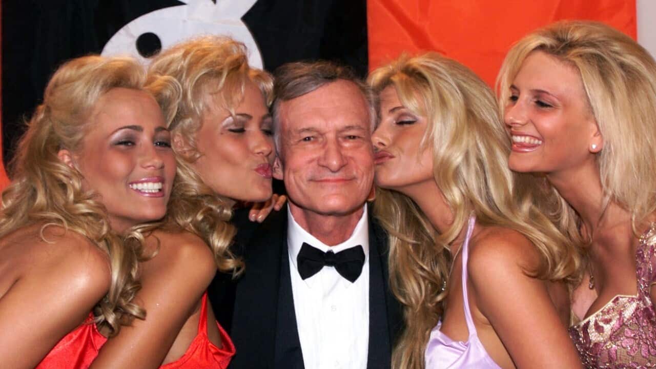 1999 file photo of Playboy founder and editor in chief Hugh Hefner receiving kisses from Playboy playmates at the Cannes Film Festival